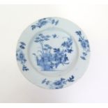 A Liverpool delftware charger  mid 18th century, painted in blue with bamboo and peony issuing