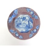An English delftware plate with a rare border  mid 18th century, painted to the well with an