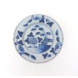 A delftware plate  mid 18th century, simply painted in blue with bamboo issuing from a fence