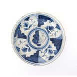 An early delftware oak-leaf charger   c.1700, decorated in blue with a typical design of a single
