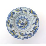 A large Delft lobed dish  c.1700, decorated in blue, yellow and manganese with a seated Chinese