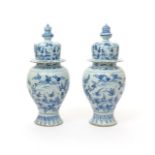 A pair of Delft vases and covers  18th century, the baluster forms painted in blue with landscape