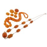 A graduated amber bead necklace, 58cm, 31g. An amber necklace of nine beads with metal chain, 34g