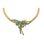 An emerald and diamond necklace, the central foliate scroll pendant, is set with oval and circular-