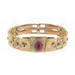 A ruby and diamond-set gold bracelet, the centre panel set with a cabochon ruby within circular-