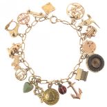 A gold oval-link bracelet mounted with assorted gold charms, including an enamel ladybird, a