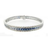 A sapphire and diamond line bracelet, set with a line of square-shaped sapphires which graduate in