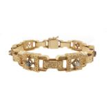 A sapphire and diamond bracelet, the textured gold links are alternately-set with a sapphire or