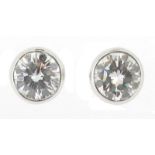 A pair of diamond studs, the circular-cut diamonds weigh approximately 0.90cts in total, rubover-set