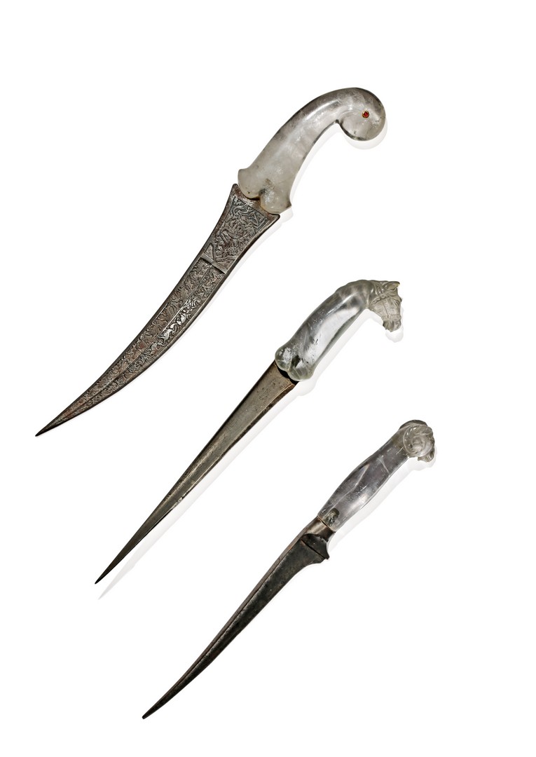 THREE MOGHUL DAGGERS WITH ROCK CRYSTAL HANDLES, 19TH CENTURY One handle carved with a ram’s head,