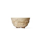 † A CHINESE IVORY BOWL, QIANLONG 1736-95 Carved in relief with two bats amongst flowering and