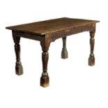 An oak centre table, the boarded top above a thumbnail lozenge frieze either side on turned and