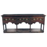 A George III oak pot-board dresser, with mahogany banding, the boarded top above three drawers and a