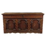 An early 17th century oak coffer, the later hinged top with a moulded front edge and crimped sides
