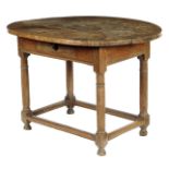 A walnut side table, the boarded oval top above an oak frieze drawer on ring turned supports