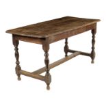 An early 18th century oak refectory table, the triple boarded top on turned legs united by an 'H'