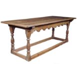 An early 18th century and later oak refectory table, the boarded top with cleated ends above a