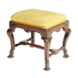 An early 18th century walnut stool, the later drop-in seat above a frieze carved with florets on