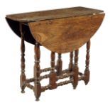 A Queen Anne elm gateleg table, the oval drop-leaf top above slender baluster and block legs