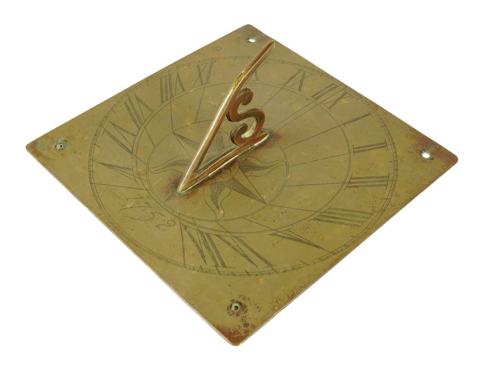 A brass sundial, with an 'S' shaped gnomon and engraved with a sun head and the date '1752', 20.1