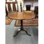 A George III mahogany tripod table, the circular tilt-top on a turned barrel stem and pointed pad