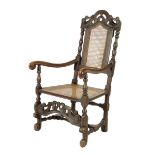 An early 18th century ebonised walnut and beech open armchair, with a scroll carved top rail above a