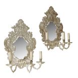 A pair of Baroque style silvered metal girandoles, each with a shaped plate within a scroll cast