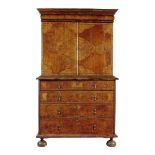 A walnut and seaweed marquetry cabinet on chest, with a cushion drawer above a pair of doors