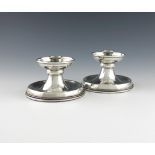 By A. E. Jones, a pair of Arts and Crafts silver candlesticks, Birmingham 1926, circular form,