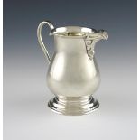 By Charles Boyton & Son, a silver cream jug, London 1928, plain baluster form, with a scroll handle,