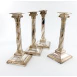 A set of four George III old Sheffield plated candlesticks, circa 1790, the columns with swirl