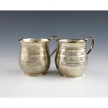 A pair of George III silver mugs, by Wallis and Hayne, London 1815, circular bellied form, with