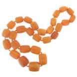 A single row graduated amber bead necklace, the barrel-shaped beads graduate from 2.4 to 3.2cm.