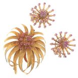 A textured yellow gold flowerhead brooch, centred with a cluster of circular-cut rubies. 4.7cm high.