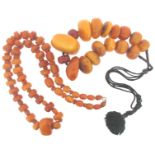 A necklace mounted with fifteen large graduated amber beads, and two red beads. 242g in total, the