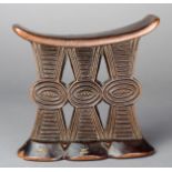 A Shona headrest Zimbabwe wood, with inlaid brass wire, the curved top with incised 'x's' with