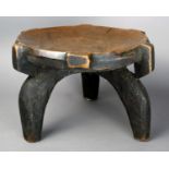A Hehe stool Tanzania wood, with a circular top on three scroll legs, one pierced at the top for