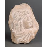 A Sumerian fragment limestone, relief carved a figural bust, with a beaded and braided coiffure