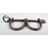 A set of iron leg shackles with painted museum number 1956.26.709, 29.5cm long. Provenance Arthur