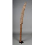 A carved wood ceremonial staff probably East Africa with a curved blade with deep carved geometric