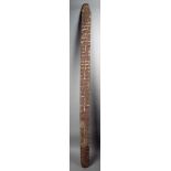 An Aborigine large churinga Australia wood, with incised linear geometric decoration, with remains