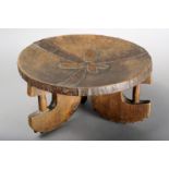 A Kamba stool Kenya wood, with metal mounts, on three 'C' shape legs with vertical supports and with