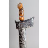 A Malayan kris with a wavy edged blade and a carved wood hilt as a stylized Garuda bird, in a