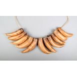 A Fiji sperm whale tooth necklace, Sisi Polynesia with eleven teeth pierced for attachment with