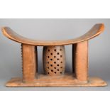 An Ashanti stool Ghana wood, with pierced and carved decoration, the underside with a hand written