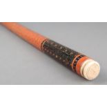 λ An Indian ceremonial baton wood, with incised lacquer decoration and turned ivory ends, early 20th