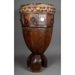 A large drum Possibly Zanzibar carved wood, raised on three scroll legs to a panelled body, with