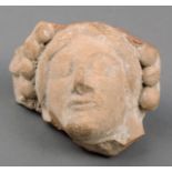 A Hellenistic female head fragment pottery, with remains of a bead edge headdress, 8cm high.