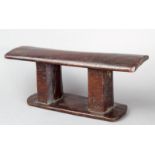 A Tonga headrest Polynesia wood, with a rounded top and flared ends, on faceted twin supports with a