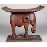 An Ashanti stool Ghana wood, with a carved elephant support, 50.5cm high, 54.5cm long.